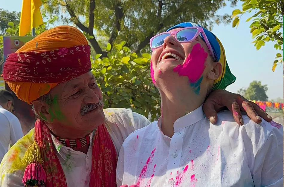 Travelers celebrating Holi during a luxury Golden Triangle tour in India with colorful powders, Jaipur palace festivities, and iconic heritage landmarks.
